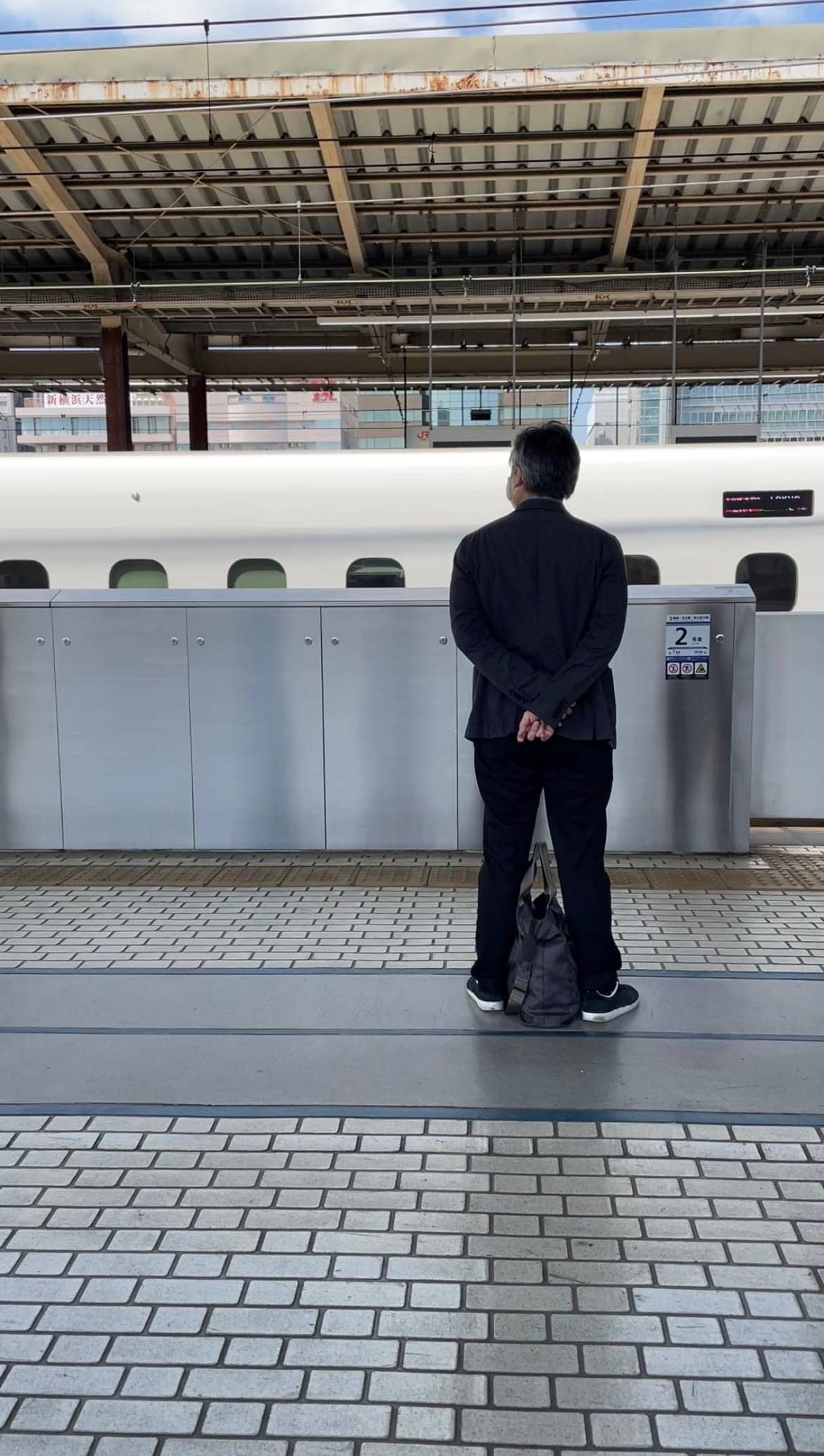 Uomo che aspetta il treno alla banchina in Giappone