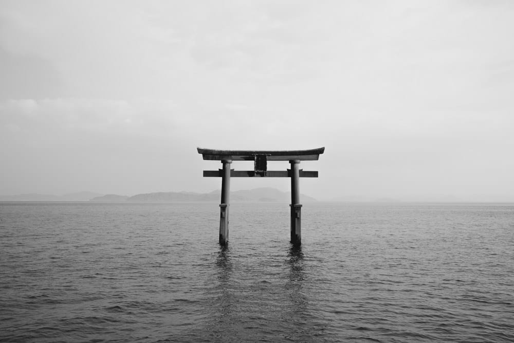 Shirahige Shrine sul lago Biwa, vicino a Kyoto. C'è un torii in acqua davanti al tempio.