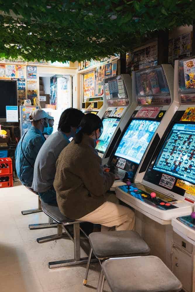 Ragazzi che giocano ad arcade games a Tokyo Akihabara