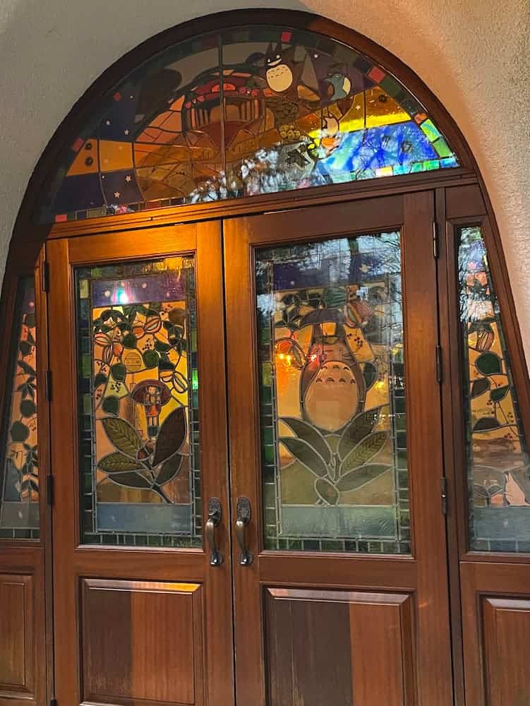 Vetrata sulla porta di ingresso del Museo Ghibli a Tokyo con diversi personaggi dello studio, tra cui Totoro in primo piano