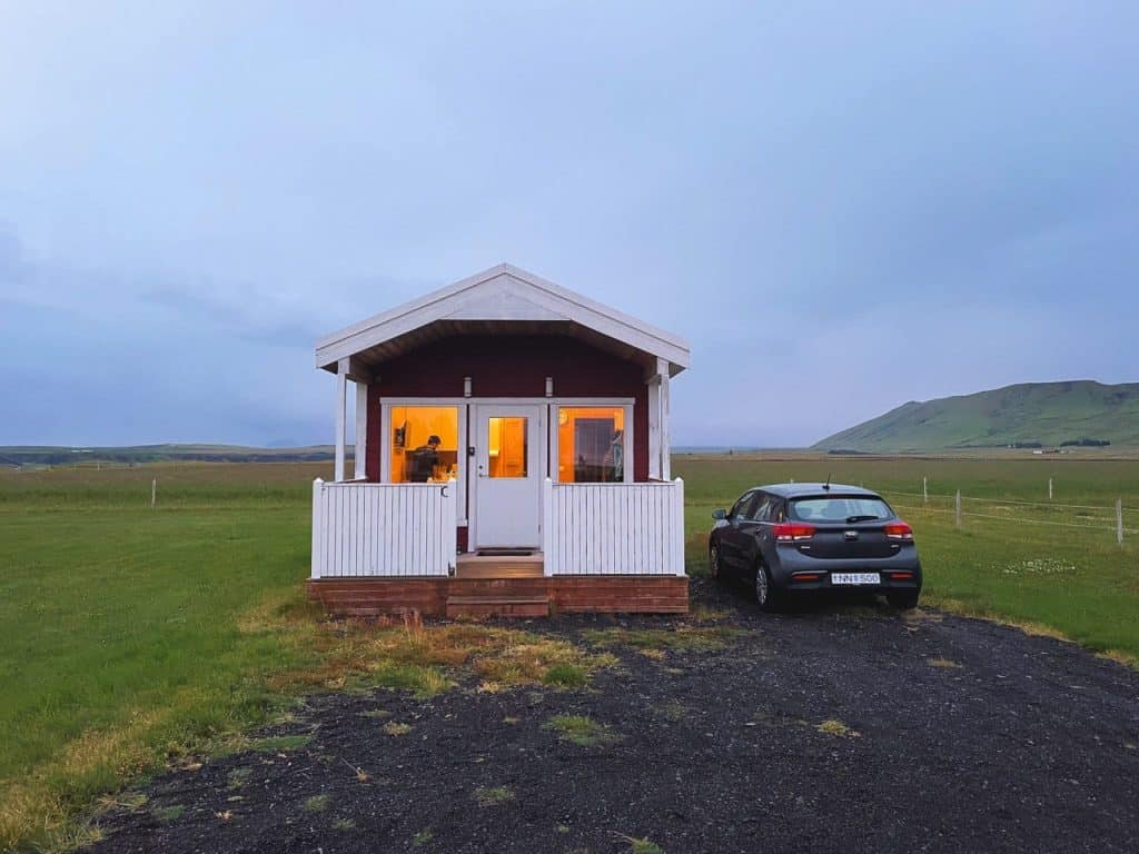 auto parcheggiata di fianco a una cabin in islanda