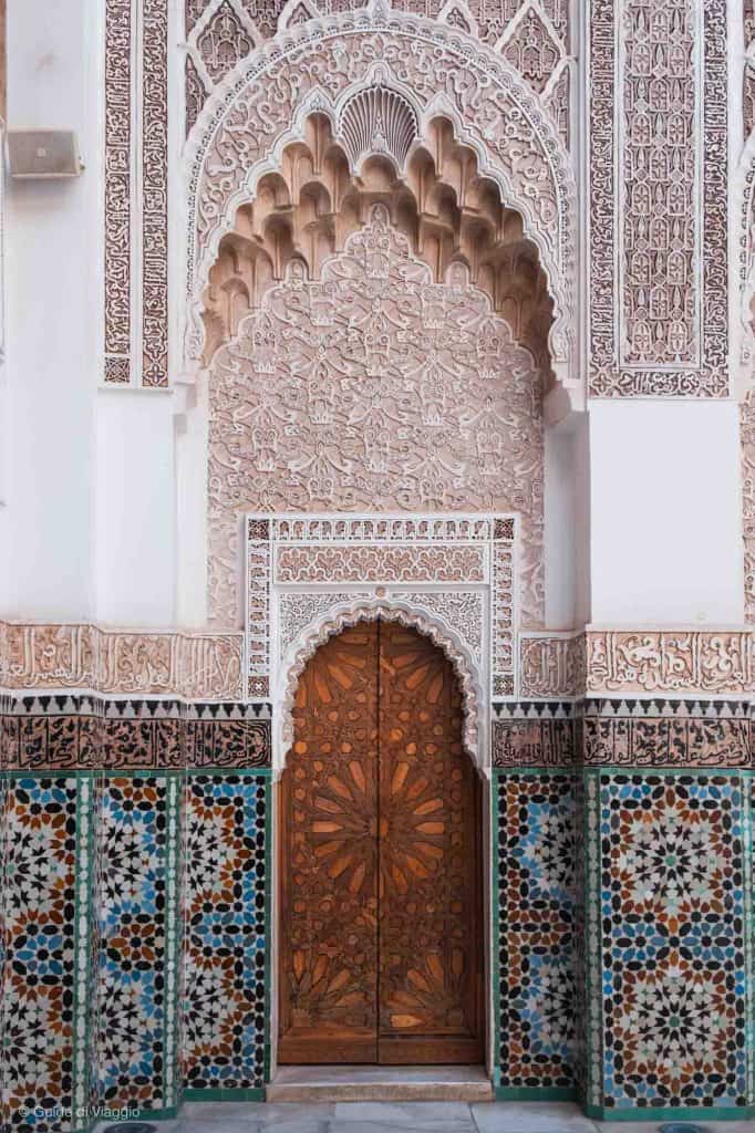 Una parete con una porta decoratissima nella Medersa di Ben Youssef
